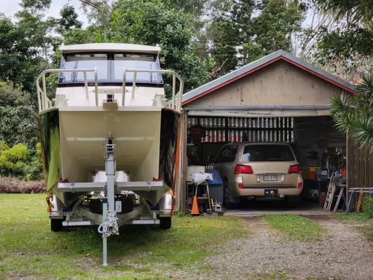 Rear view of a hardtop boat on a trailer at home