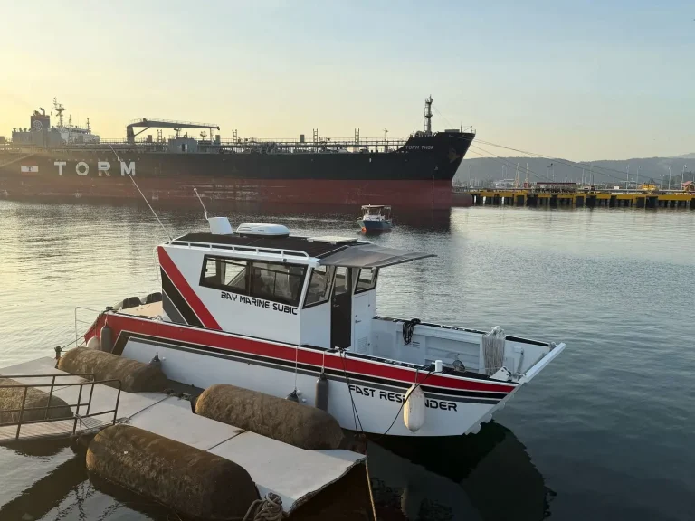 Red and white plate aluminium work boat at the port