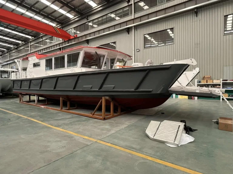 Red hulled plate aluminium work boat in the factory