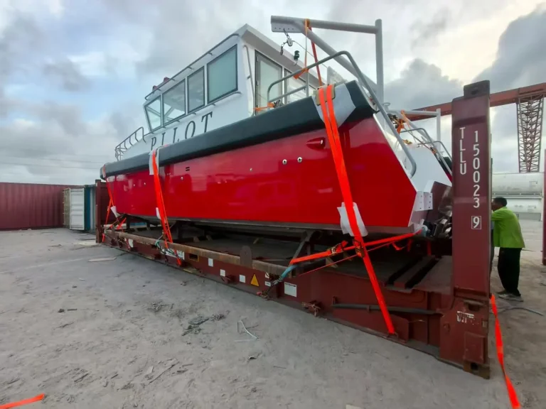 Red pilot boat being loaded for shipping