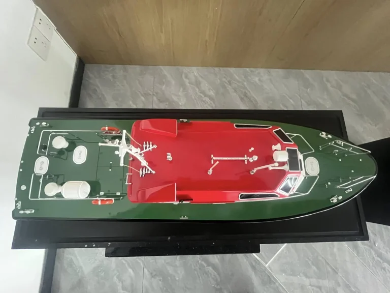 Scale model of a red work boat from above