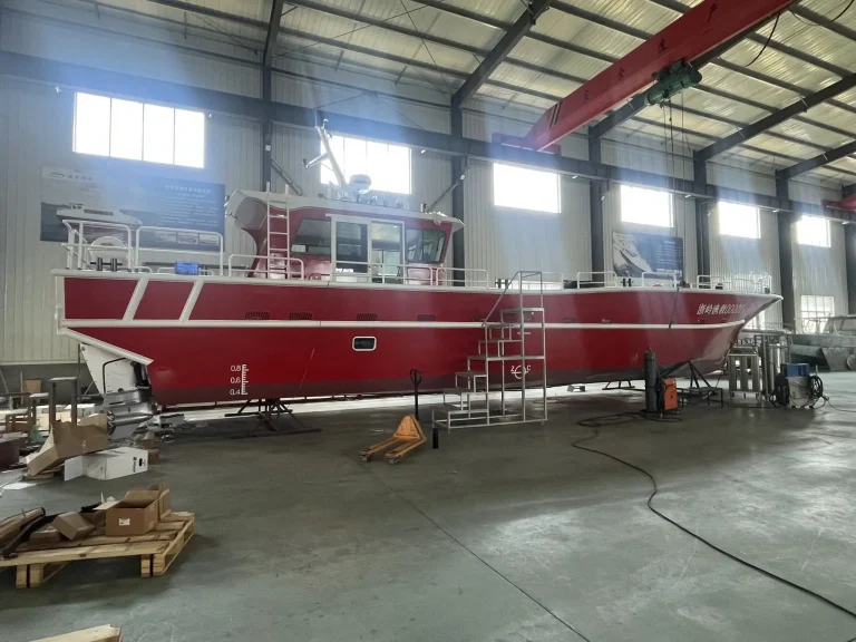Side view of a red plate aluminium work boat