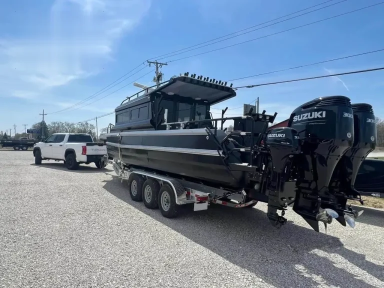 Stern of a hardtop boat with twin outboards on a trailer