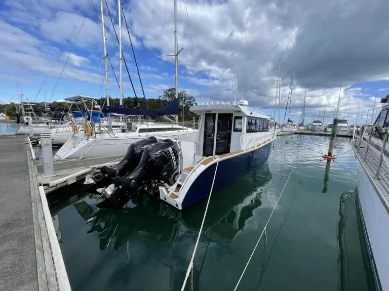 Stern quarter of a plate aluminium boat berthed in a marina