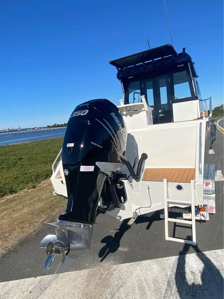 Stern view of a hardtop boat with outboard on a trailer