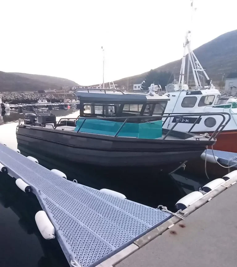 Teal and black plate aluminium cabin boat at a wharf