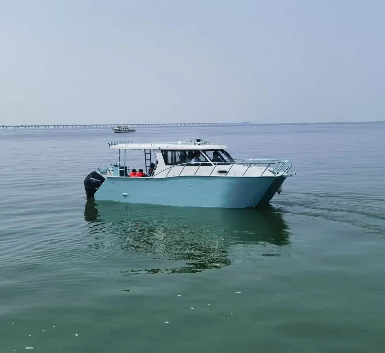 Teal plate aluminium cabin boat idling on flat water