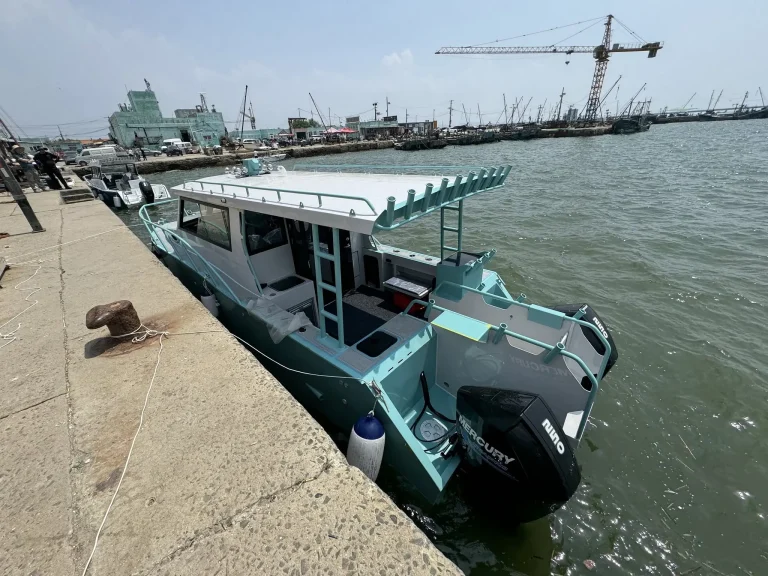 Teal plate aluminium passenger boat at a wharf