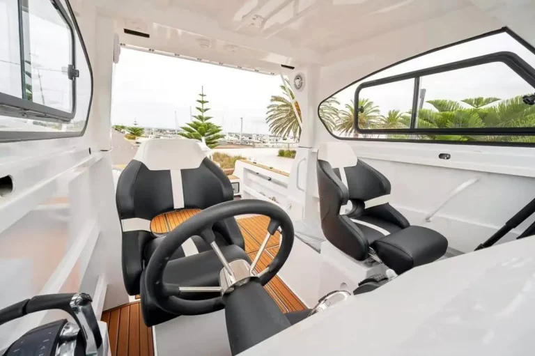 Twin helm seats and wheel inside a hardtop cabin