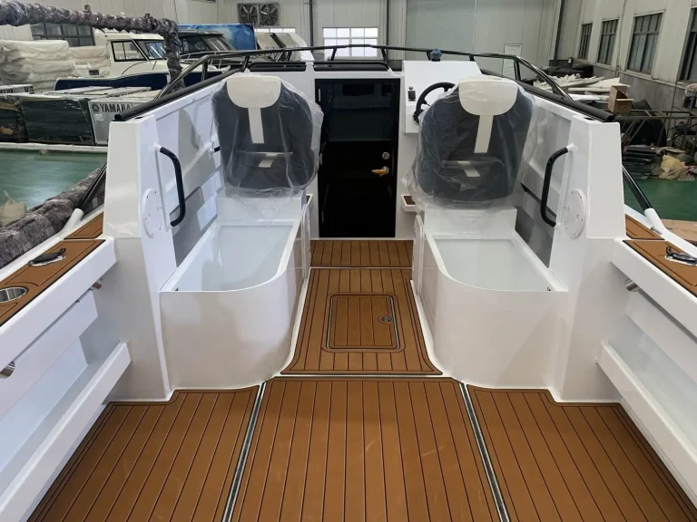 Twin helm seats over teak look flooring in an open cabin