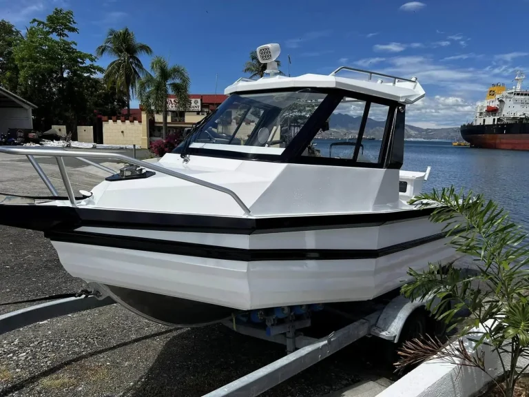 White hardtop plate aluminium boat at a tropical marina