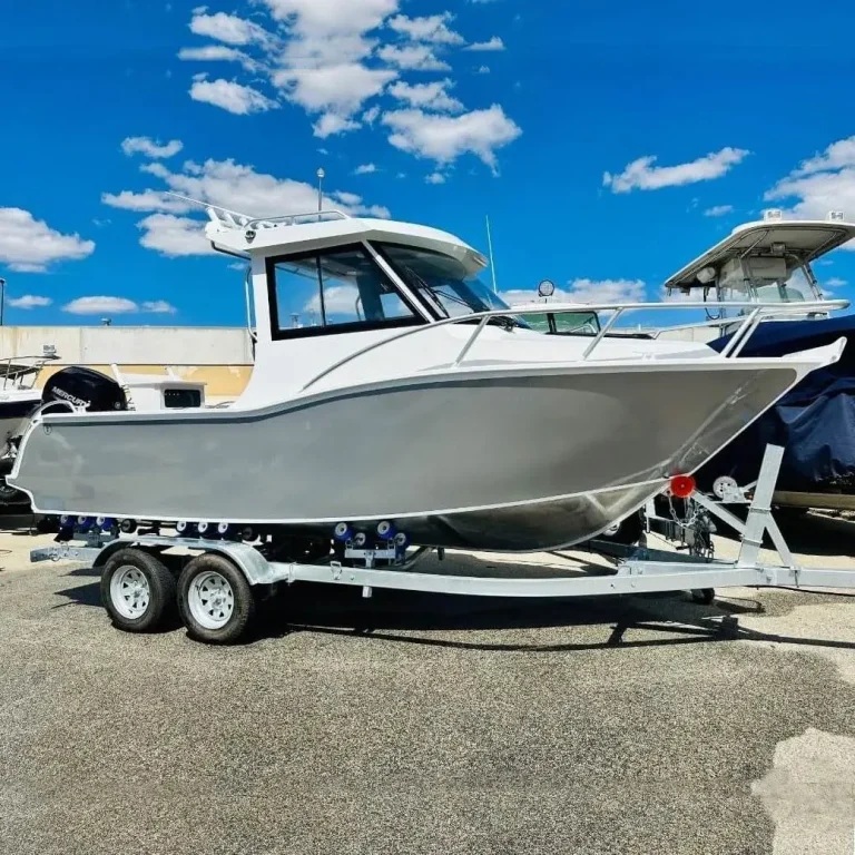 White plate aluminium hardtop boat on a trailer by the water