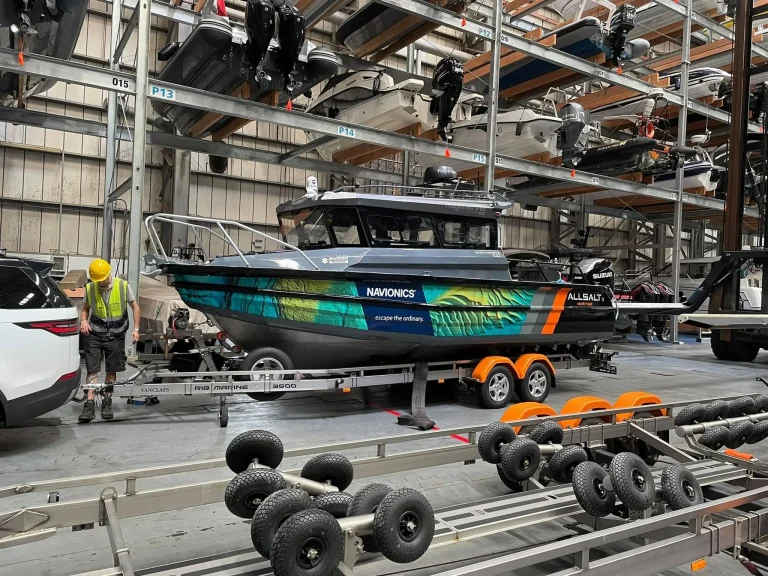 Wrapped hardtop boat on a trailer being finished inside the factory