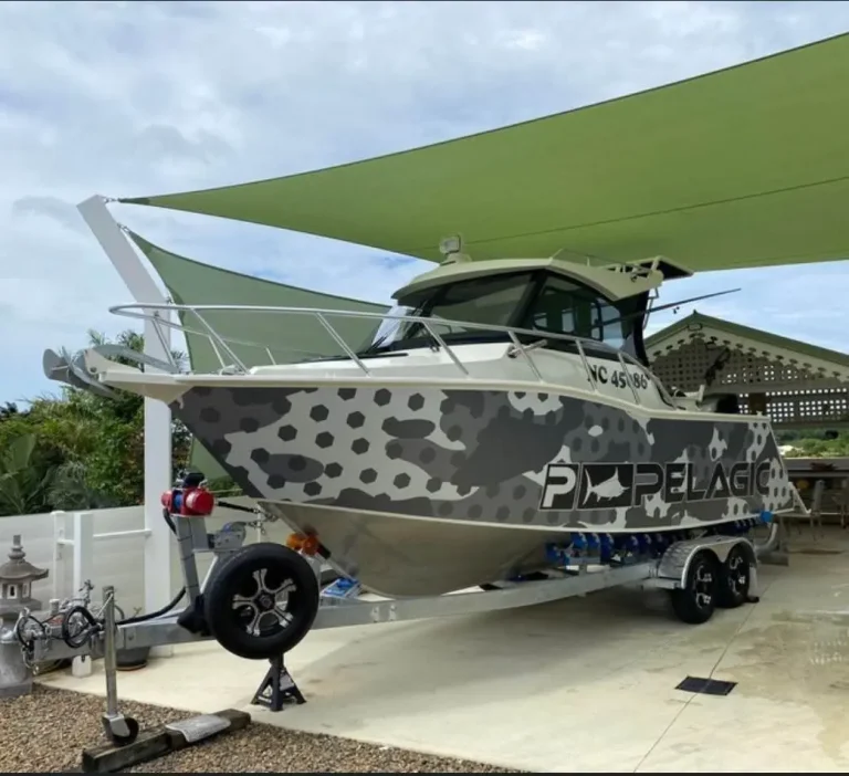 Wrapped hardtop fishing boat under a shade sail