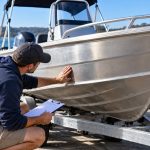 Marine surveyor inspecting a used aluminium fishing boat before purchase