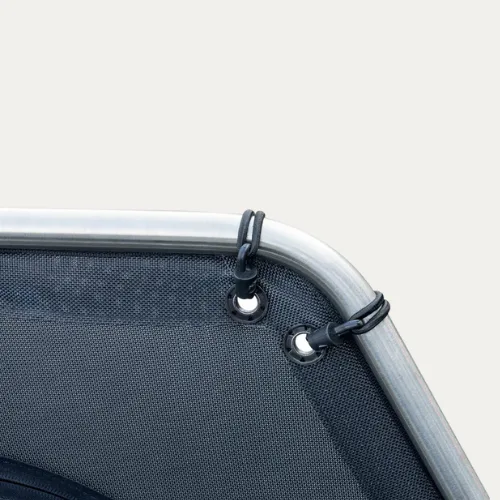 Close-up of stainless eyelets and bungee cords holding a D-Flector mesh cover to the stone guard frame corner
